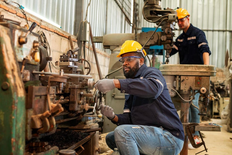Ingeniero de la industria de fábrica que usa trabajo uniforme de seguridad y sistema de verificación de robots de soldadura para soldadura eléctrica de acero con sistema de control de robot automático para el concepto de fabricación industrial.
