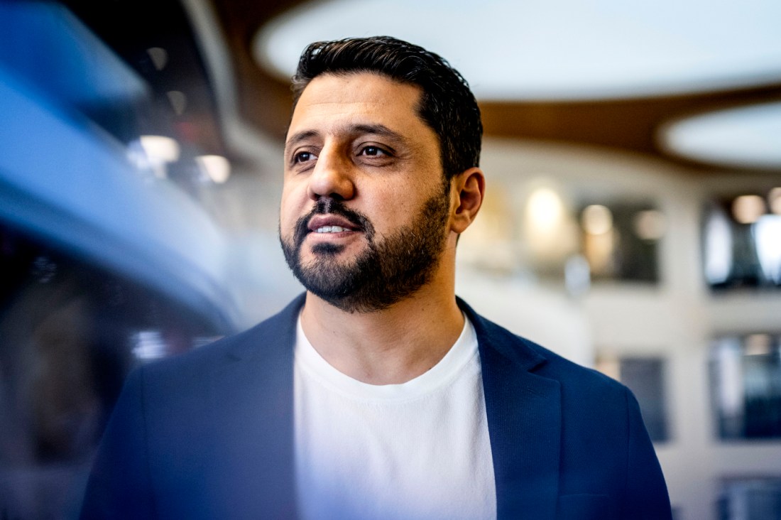 Foto de Alper Koparan con una chaqueta azul sobre una camiseta blanca.