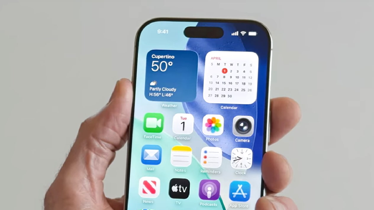 Una persona sosteniendo un iPhone con iOS 26.