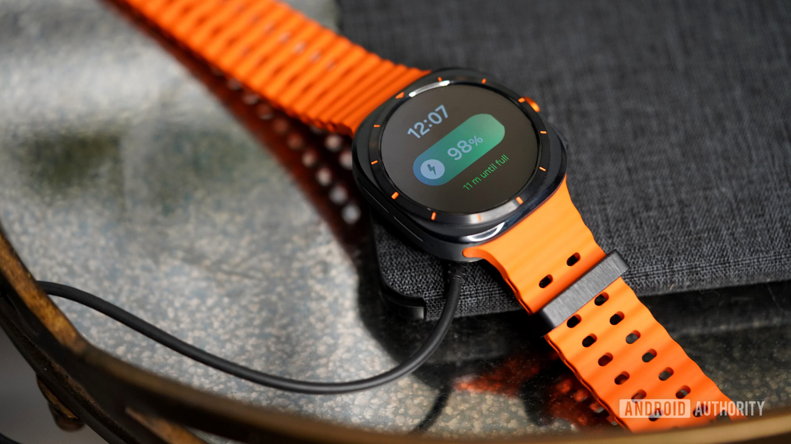 Carga del reloj Galaxy Ultra Galaxy Watch Ultra descansa sobre su cargador.