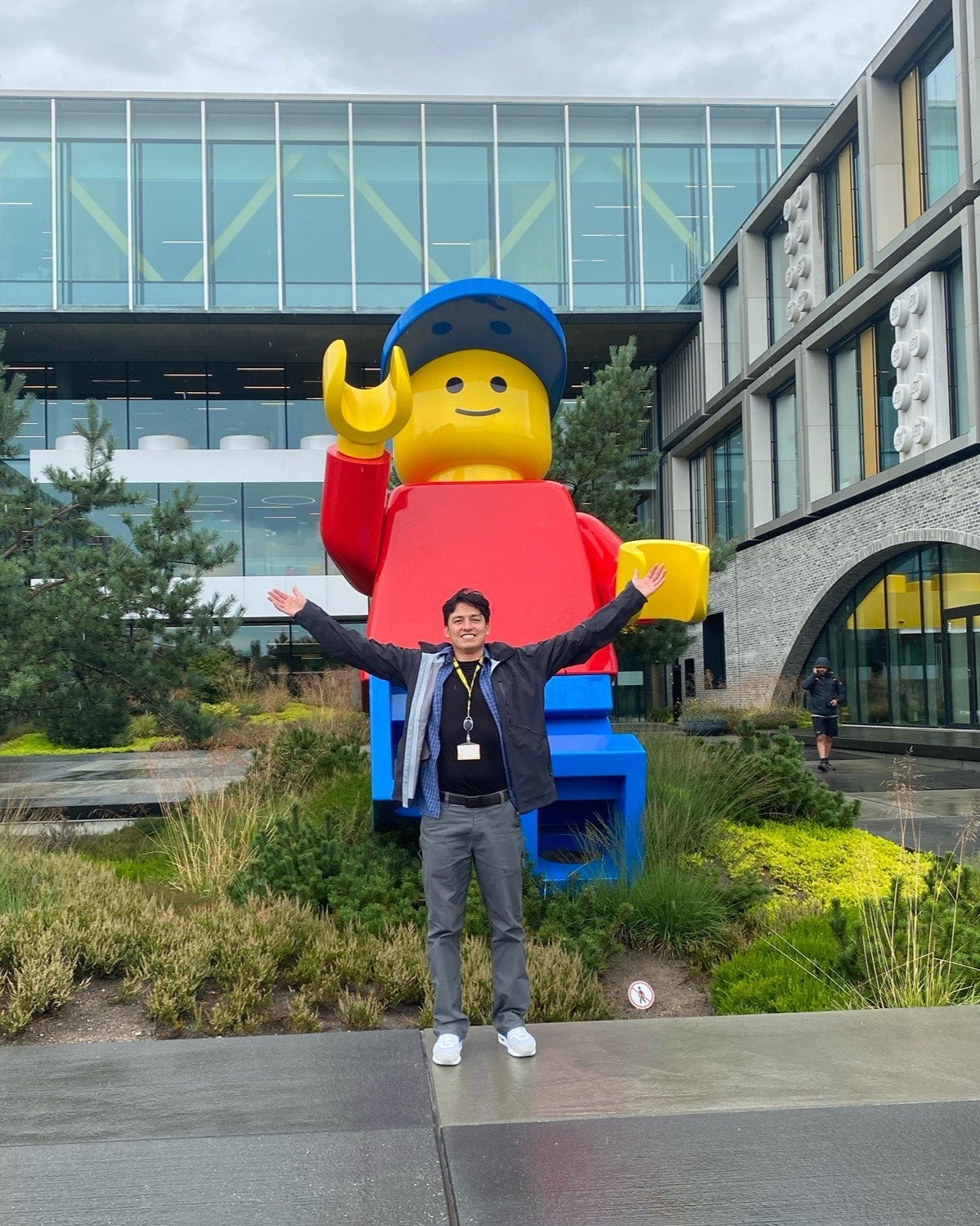 Gonzales sonríe y abre los brazos frente a un hombre LEGO gigante