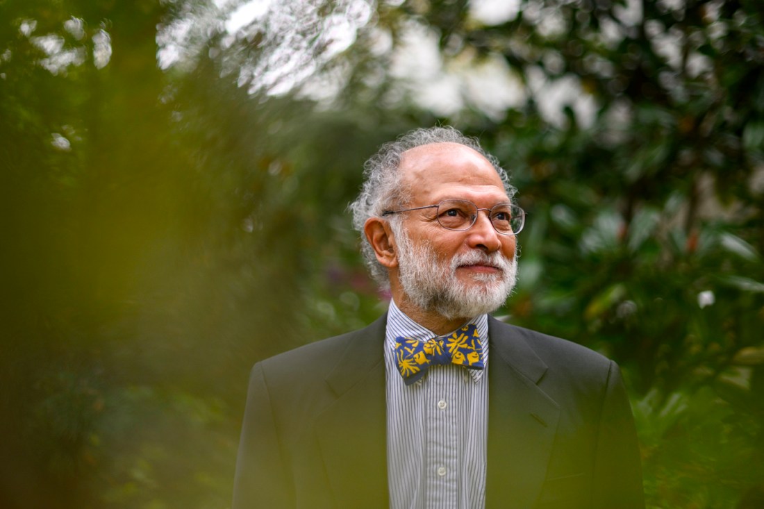 Una foto de Ravi Sarathy con una camisa a rayas, una chaqueta negra y una pajarita azul con patrones geométricos amarillos.