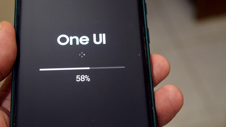 dedos sosteniendo la actualización del teléfono inteligente samsung one ui