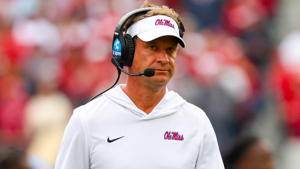 Lane Kiffin camina hacia el margen