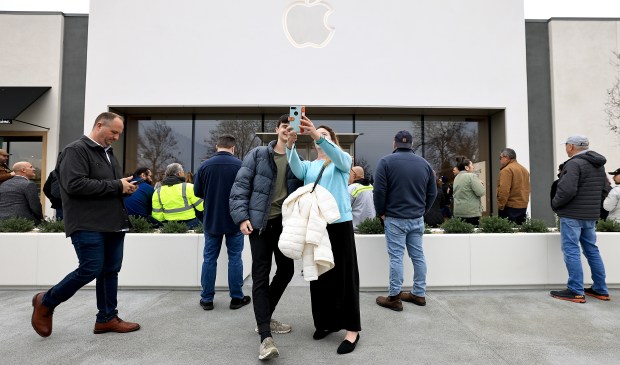 Katherine y su hijo Colin McCue de Petaluma registran el Monet mientras esperan que se abra la nueva tienda Apple en Montgomery Village, el viernes 23 de enero de 2026. (Kent Porter / The Press Democrat)