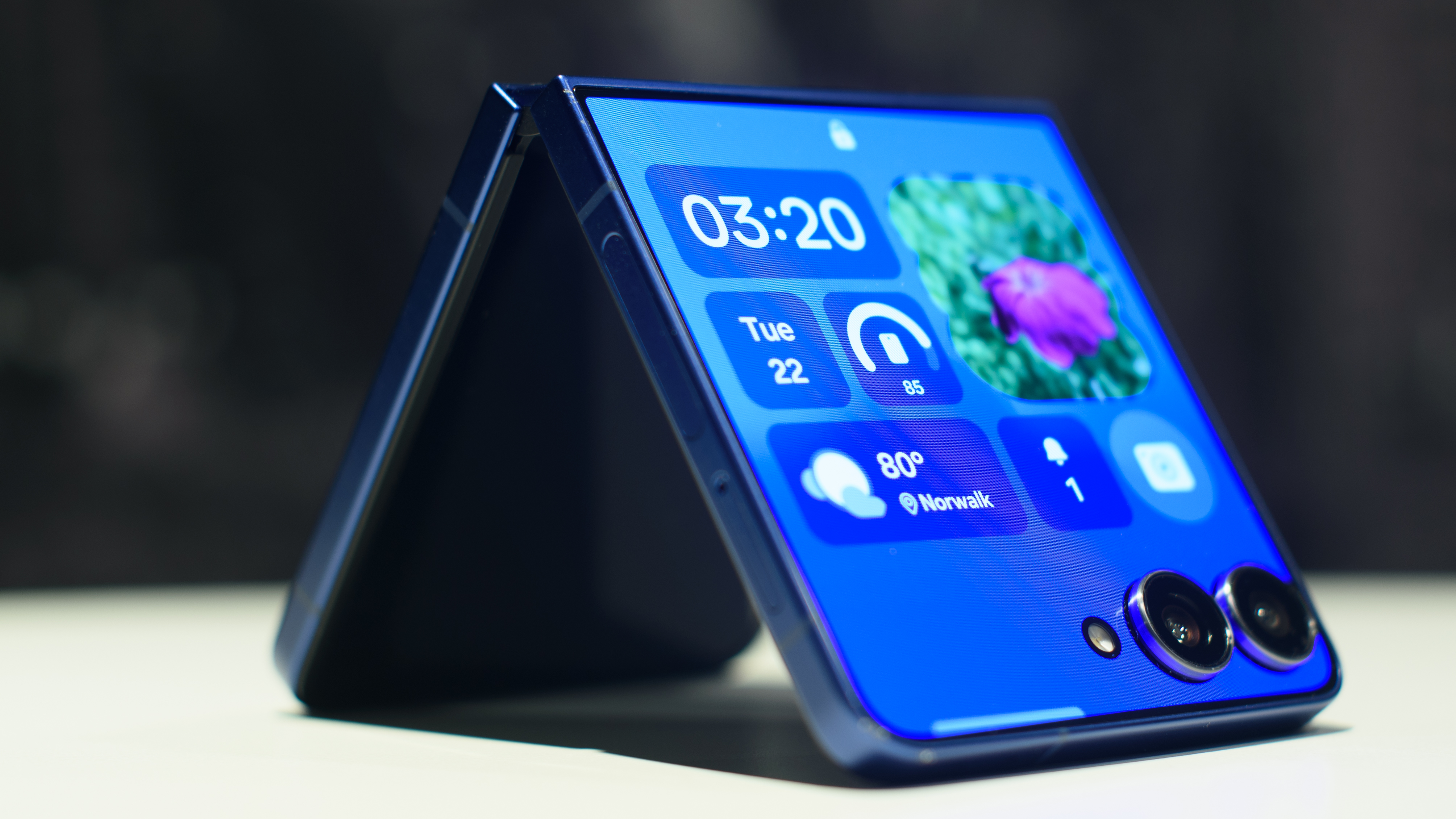 Samsung Galaxy Z Flip 7 en azul plegado mostrando widgets en la pantalla de la cubierta