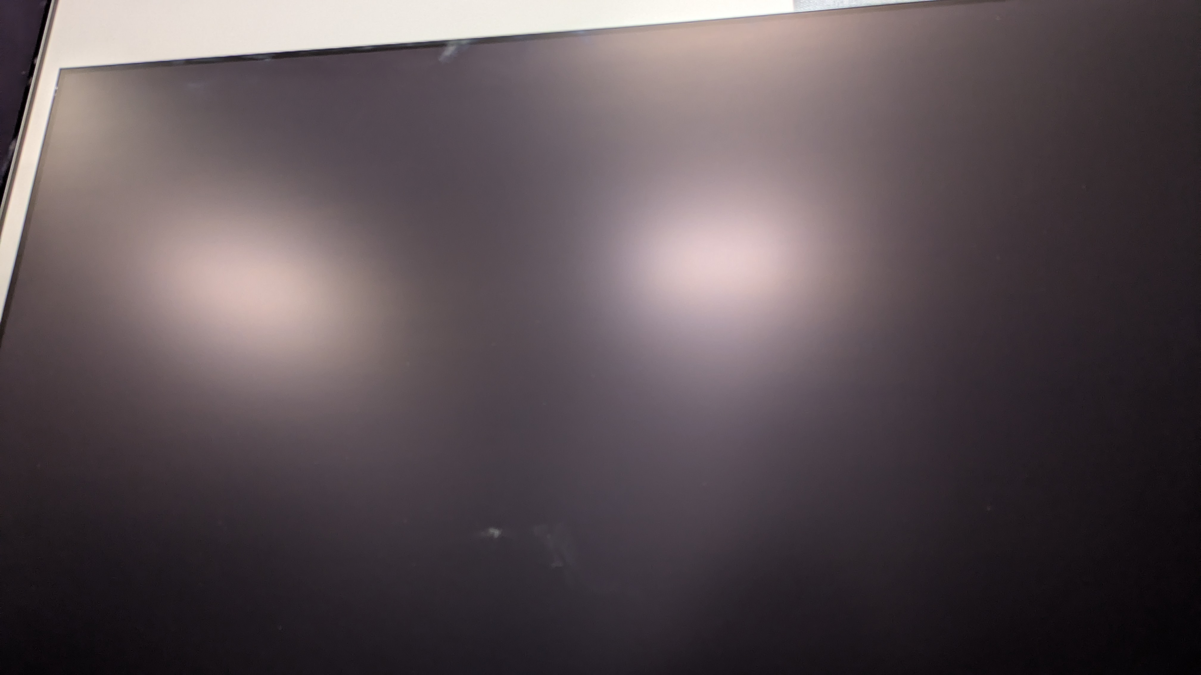 Samsung S95F con luces del techo reflejadas en la pantalla