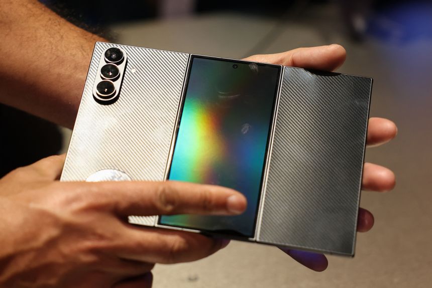 Los asistentes cierran la pantalla del teléfono inteligente Samsung Galaxy Z TriFold durante el evento Samsung Electronics First Look antes del Consumer Electronics Show (CES) en Las Vegas el 4 de enero de 2026.