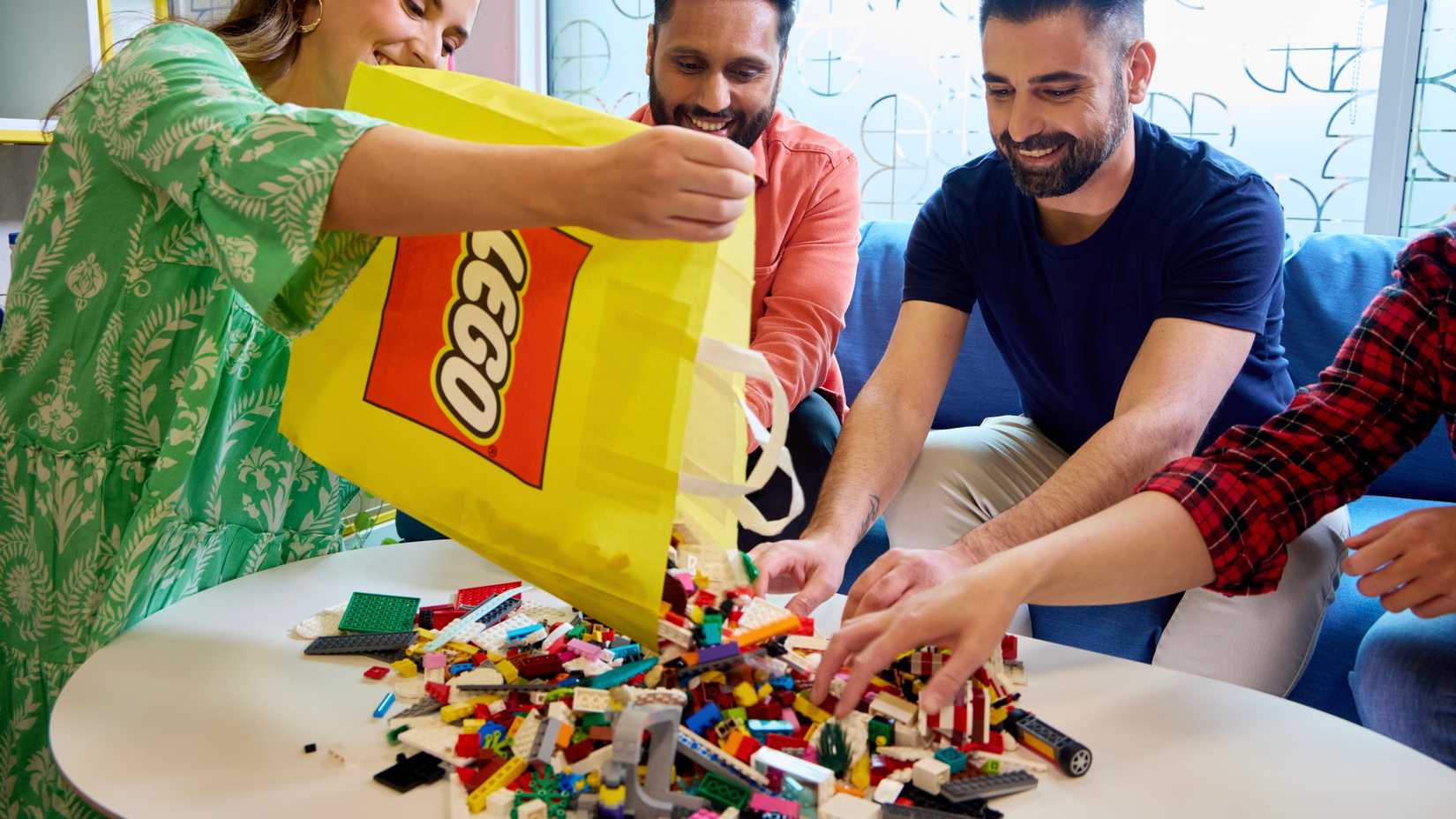 Imagen promocional que muestra personas construyendo Lego.