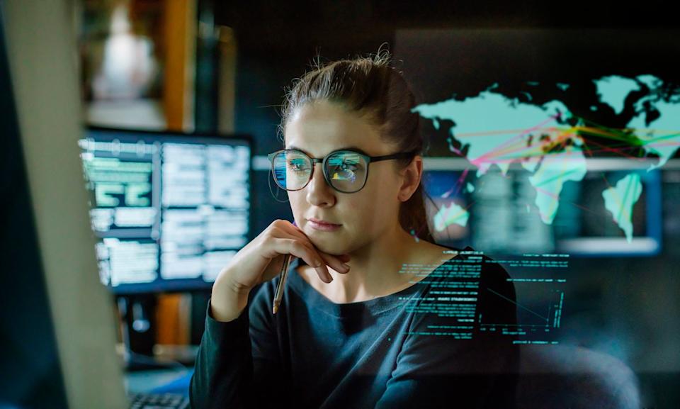 Una persona mira gráficos y tablas en un monitor de computadora.