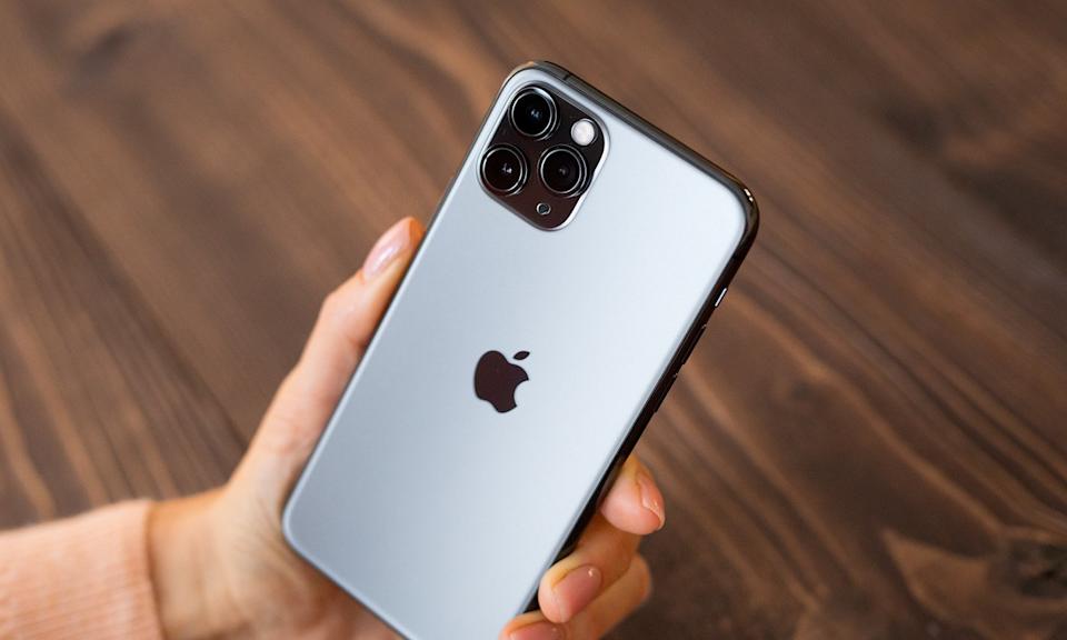Una mano sosteniendo un iPhone que muestra el logo de Apple.
