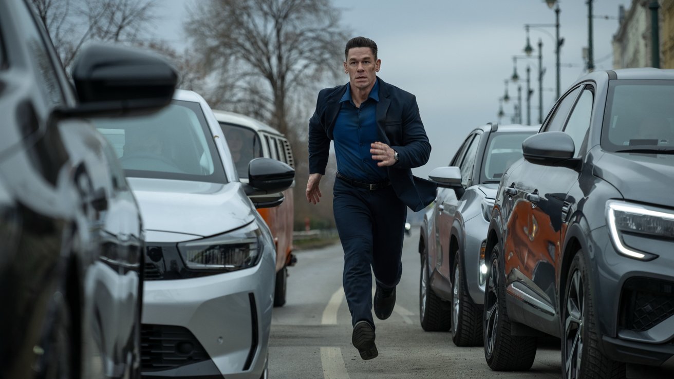 John Cena en traje corriendo entre autos en una calle