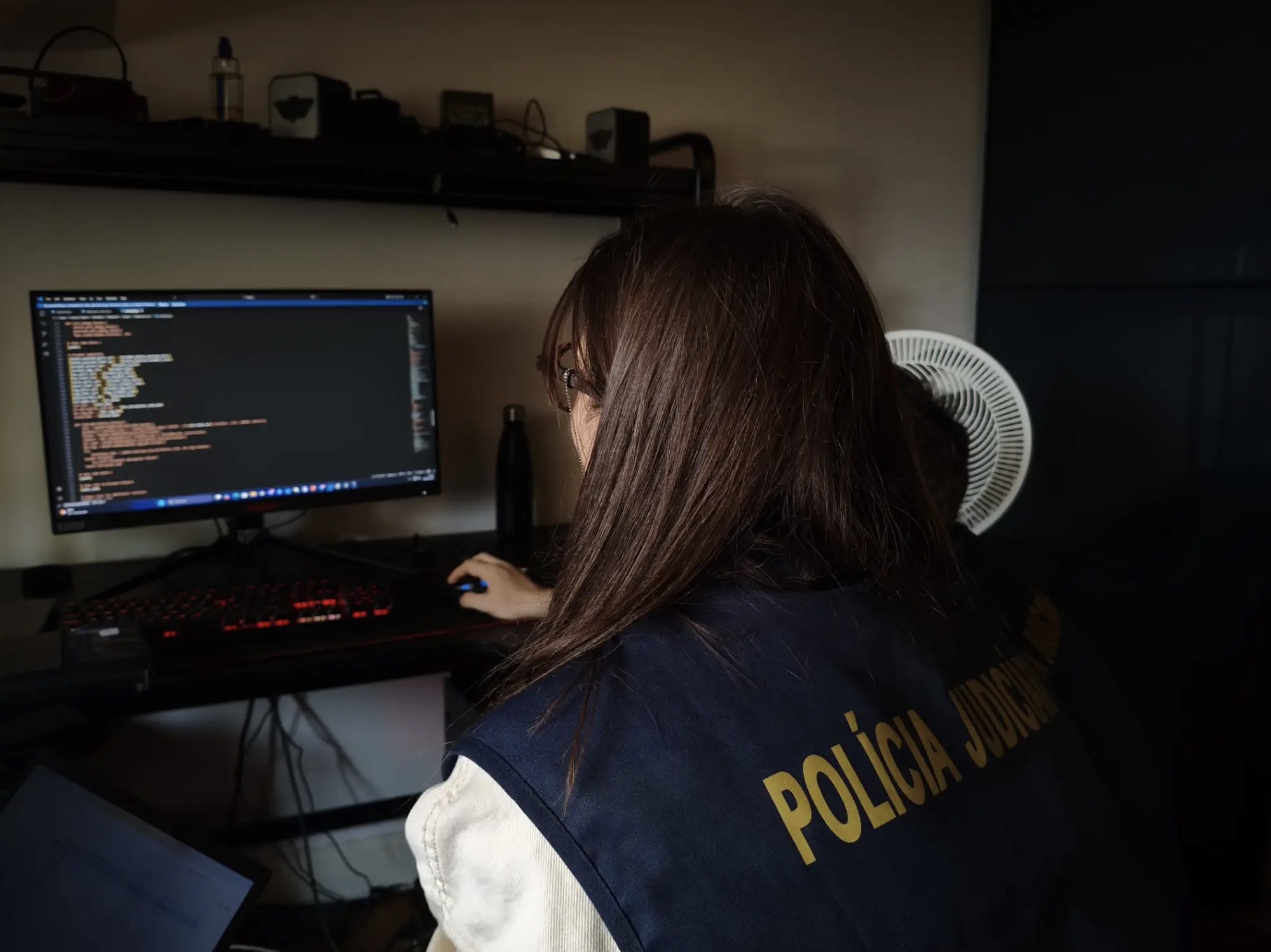 Foto de un oficial de policía europeo examinando la computadora personal de un miembro del foro.