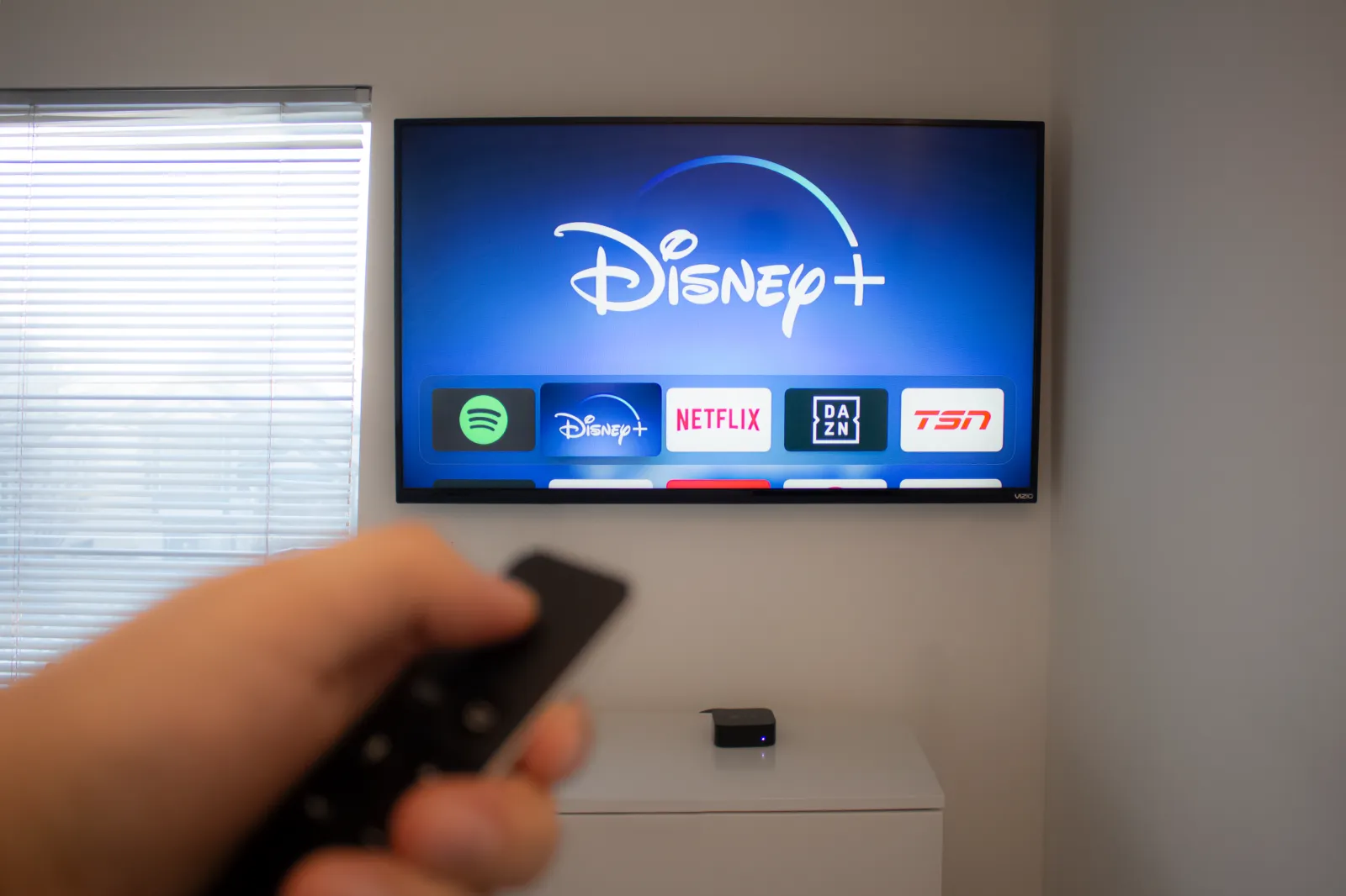 A person holds an Apple TV remote using the new Disney+ app on a Vizio TV. Disney+ video streaming service will exclusively show Star Wars: Jedi Template Challenge. Source: Getty Images.